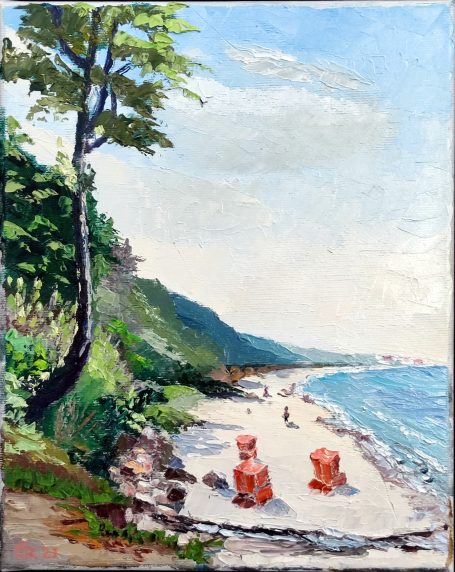 Strandansicht mit roten Strandkörben, Bäumen und glitzerndem Wasser.